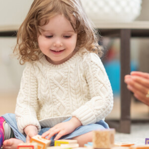 Young girl playing with wooden blocks